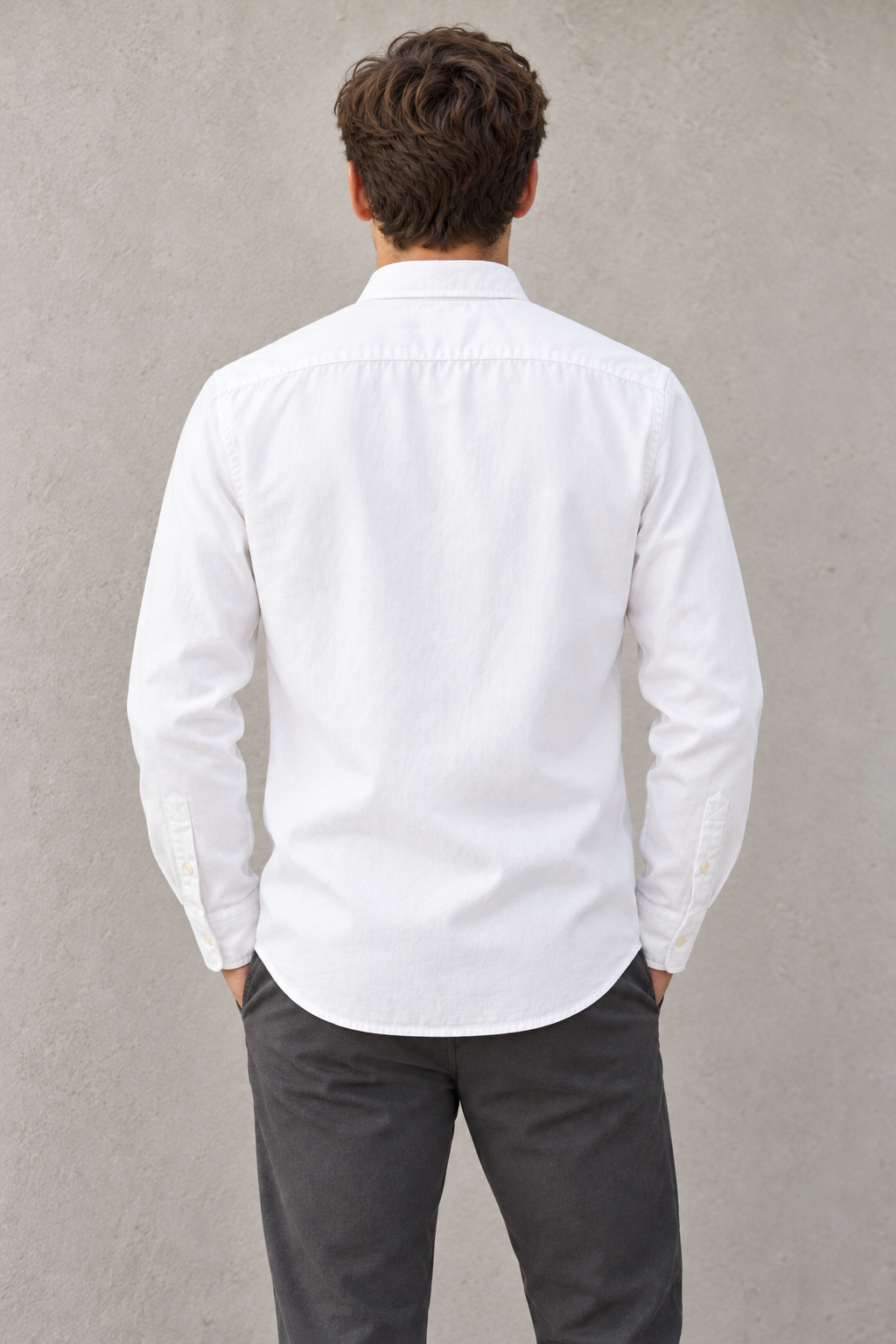 Modelo con camisa blanca LaPanda y pantalón oscuro, vista trasera.