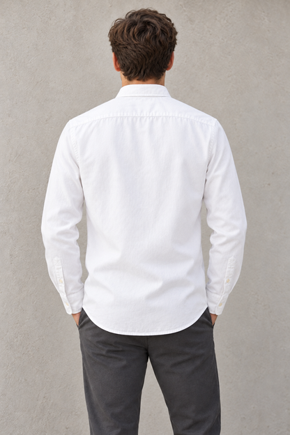 Modelo con camisa blanca LaPanda y pantalón oscuro, vista trasera.