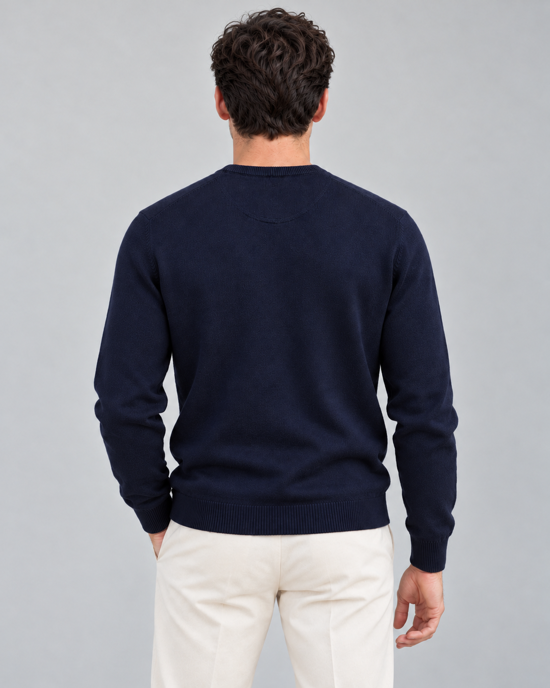 Modelo de espaldas con jersey azul marino de LaPanda y pantalones crudos, espalda lisa y acabados de canalé