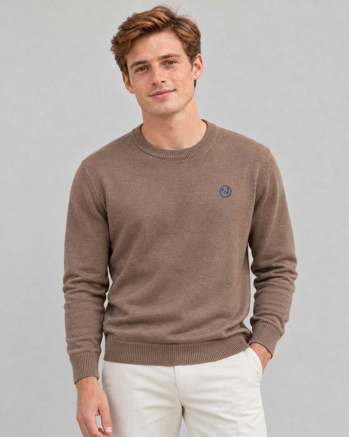 Modelo con jersey marrón claro de LaPanda, cuello redondo y bordado azul, combinado con pantalones crudos, vista frontal
